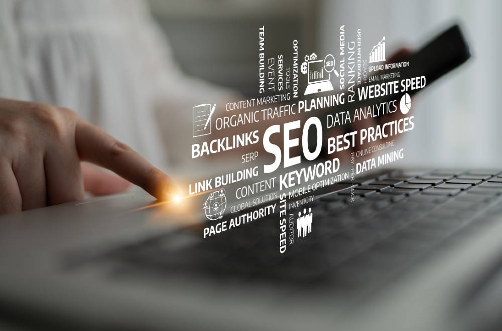 A person interacting with a laptop displaying SEO-related concepts such as keywords, backlinks, organic traffic, website speed, and data analytics, representing digital marketing and search engine optimization strategies.