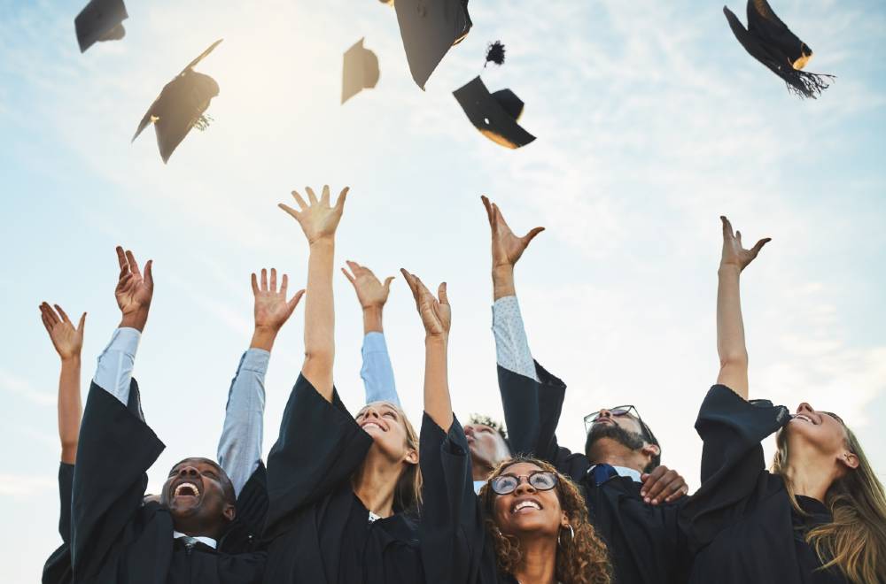 Students graduating, representing the success of digital marketing strategies by a marketing agency for higher education in boosting enrollment and engagement.